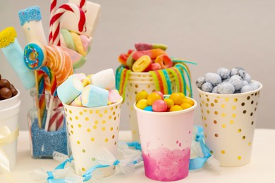 Candy bar. Different yummy sweets on white table against grey background, closeup