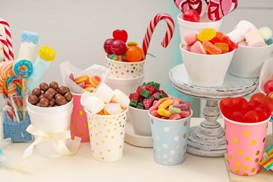 Photo of Candy bar. Different yummy sweets on white table against grey background