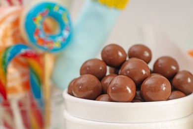 Candy bar. Chocolate sweets in paper cup on blurred background, closeup