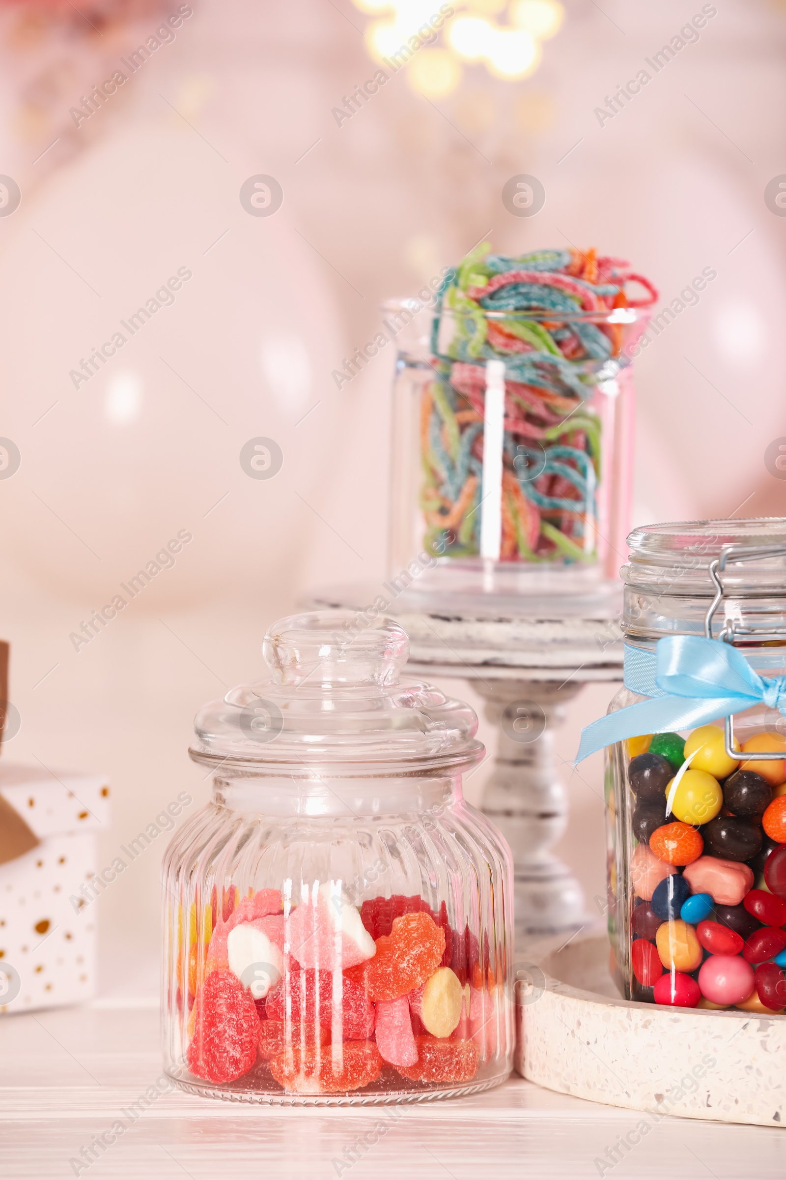 Photo of Candy bar. Many different sweets on white wooden table in festive decorated room