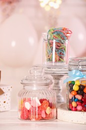 Candy bar. Many different sweets on white wooden table in festive decorated room