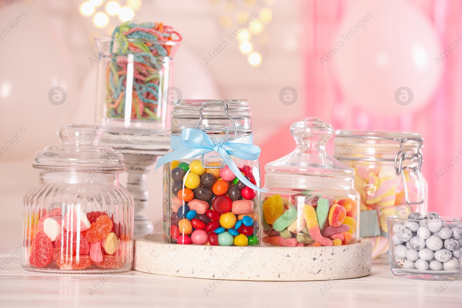 Photo of Candy bar. Many different sweets on white wooden table in festive decorated room