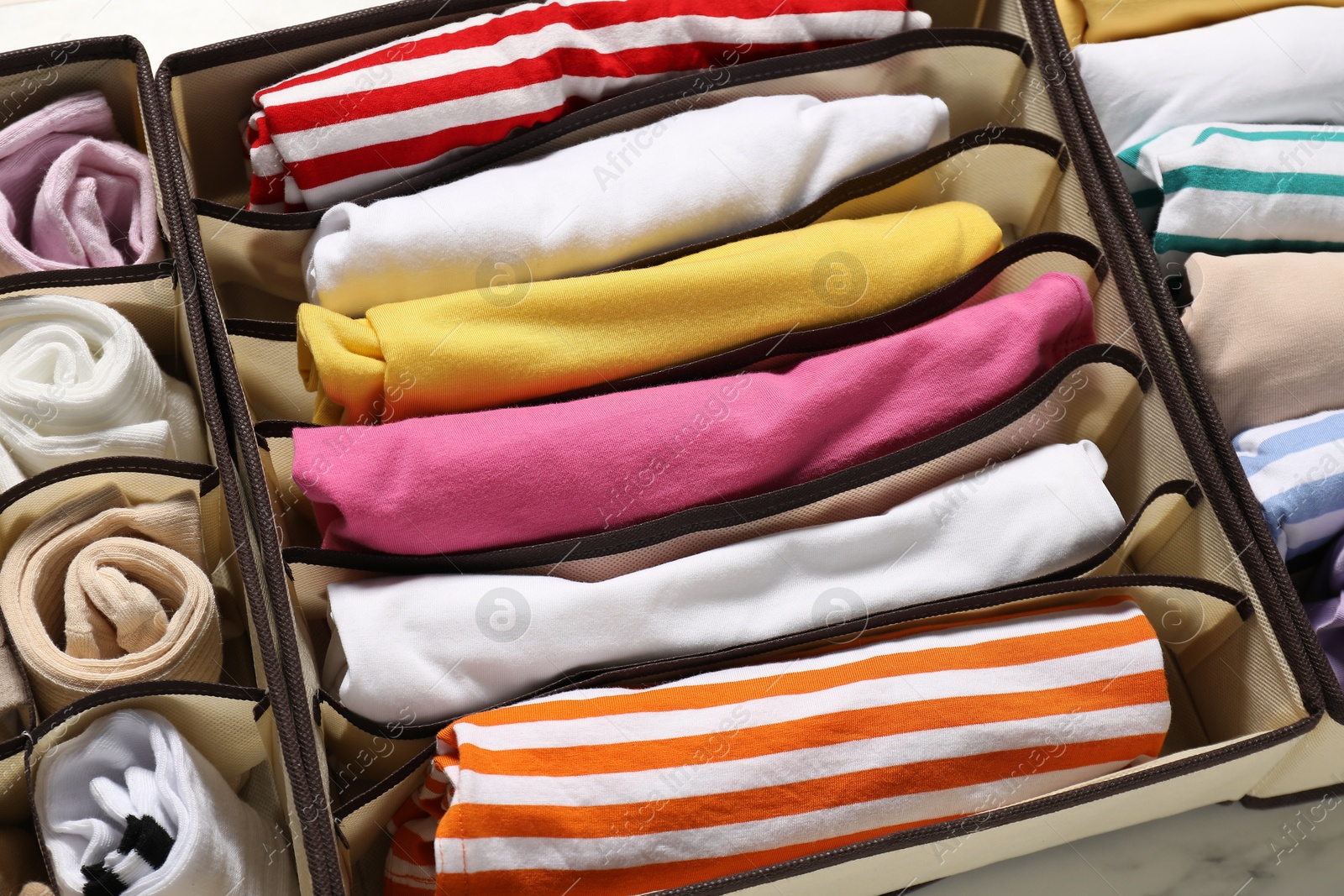 Photo of Organizers with folded clothes on table, above view