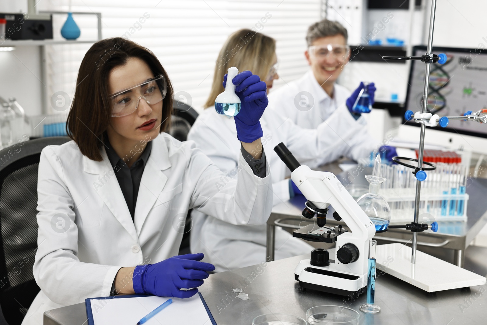 Photo of Scientist holding flask with sample in laboratory