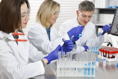 Scientists working with samples at table in laboratory