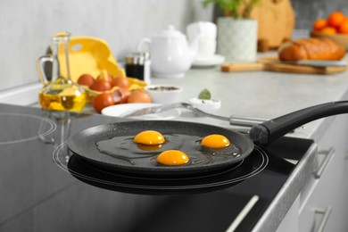 Cooking tasty eggs on frying pan in kitchen, closeup