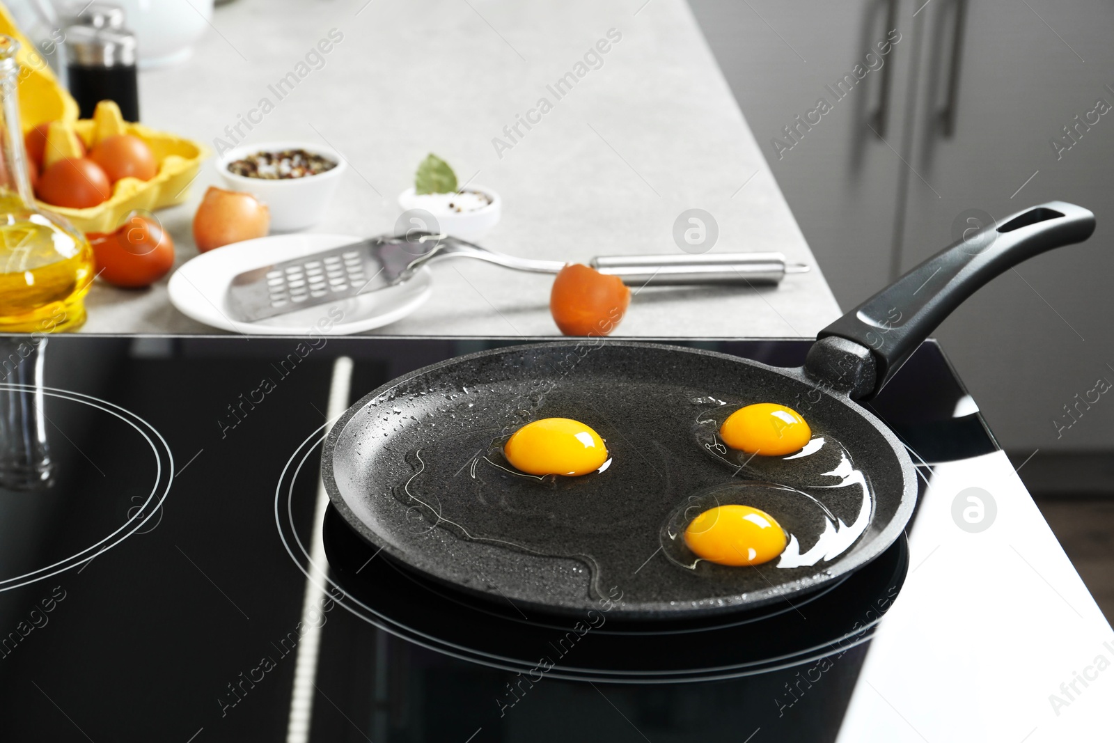 Photo of Cooking tasty eggs on frying pan in kitchen, closeup