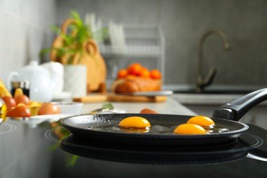 Photo of Cooking tasty eggs on frying pan in kitchen, closeup