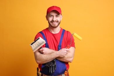 Professional painter with tools on orange background