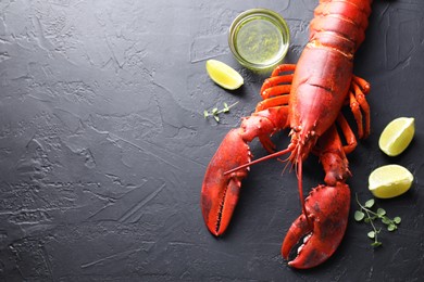 Photo of Delicious boiled lobster with lime pieces, oil and microgreens on black table, flat lay. Space for text