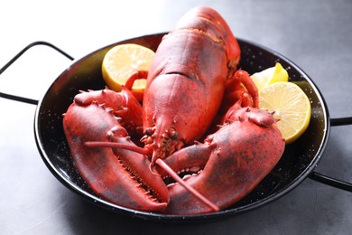 Photo of Delicious boiled lobster with lemon pieces on grey table, closeup