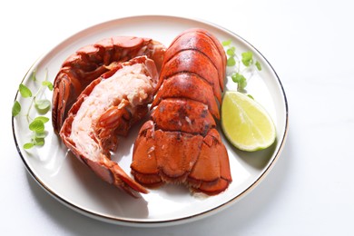 Photo of Delicious tails of boiled lobsters served on white table, closeup