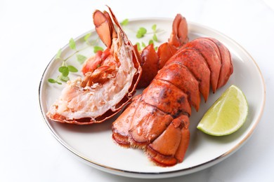 Photo of Delicious tails of boiled lobsters served on white table, closeup