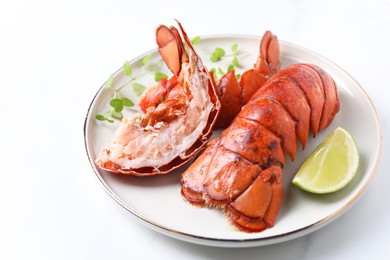 Photo of Delicious tails of boiled lobsters served on white table, closeup