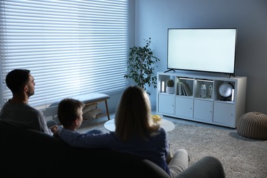 Happy family watching tv together at home