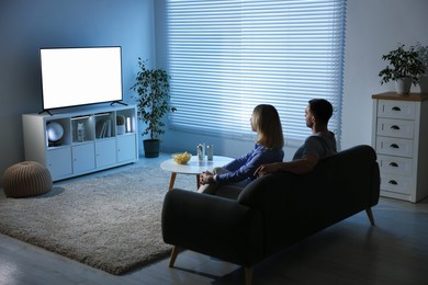 Photo of Lovely couple watching tv on couch at home