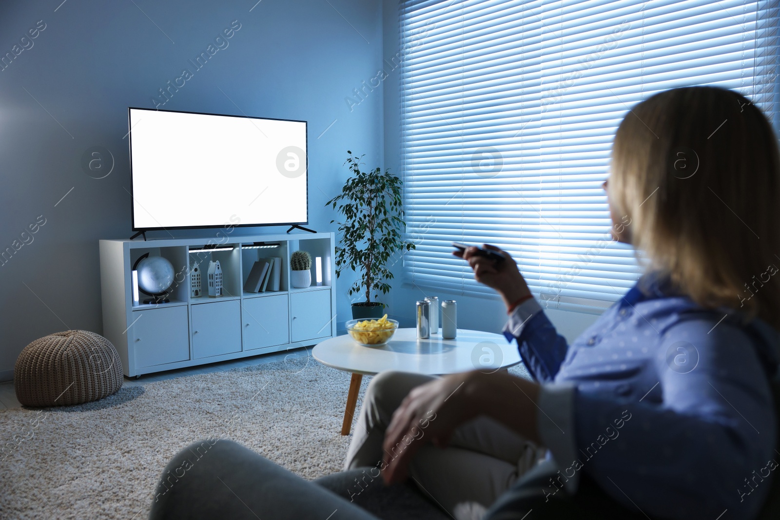 Photo of Woman watching tv on couch at home