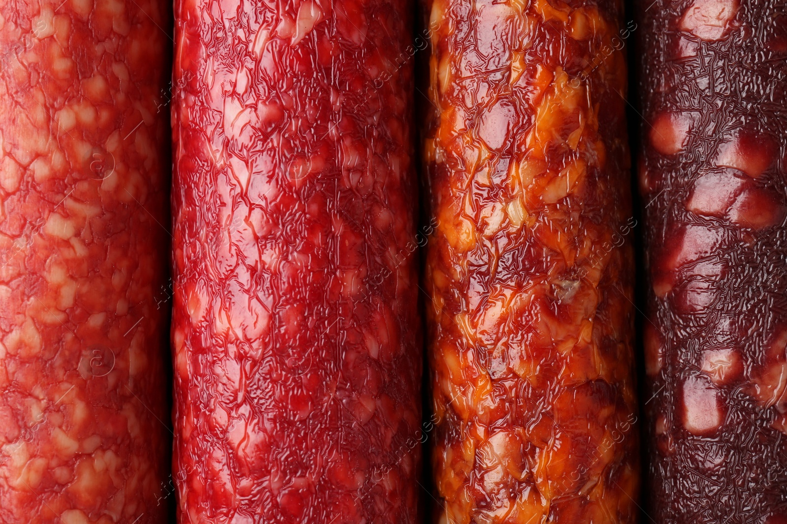 Photo of Different tasty smoked sausages as background, top view