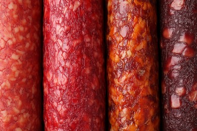 Photo of Different tasty smoked sausages as background, top view