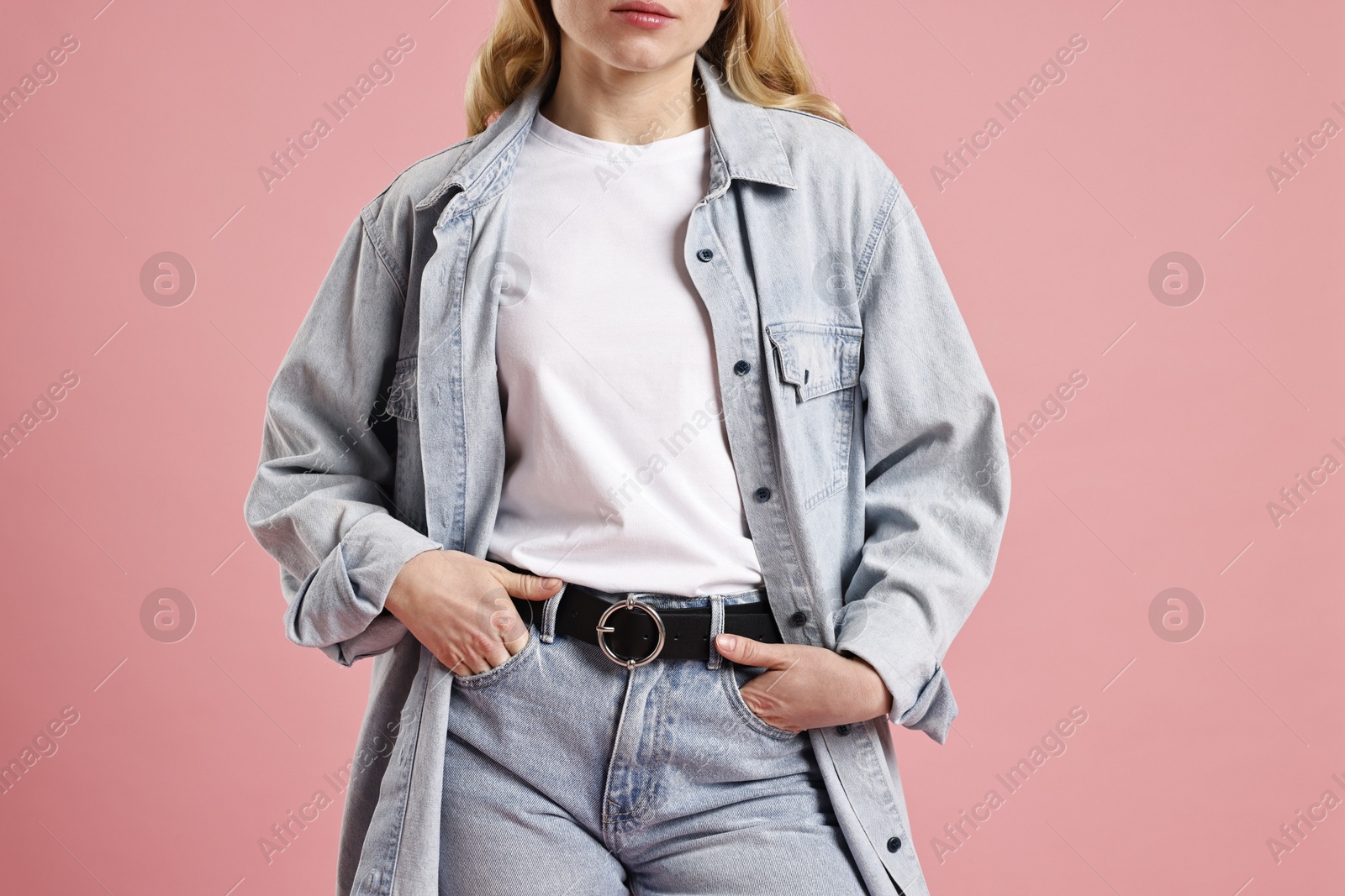 Photo of Woman in stylish jeans on pink background, closeup