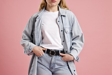 Woman in stylish jeans on pink background, closeup