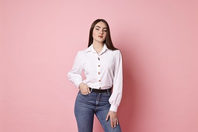 Photo of Beautiful young woman in stylish jeans on pink background