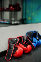 Photo of Different protective boxing gloves near light wall indoors