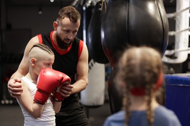 Boxing coach training children in sport center