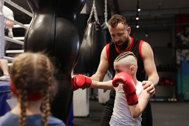 Boxing coach training children in sport center