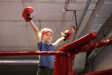 Girl in protective gloves on boxing ring