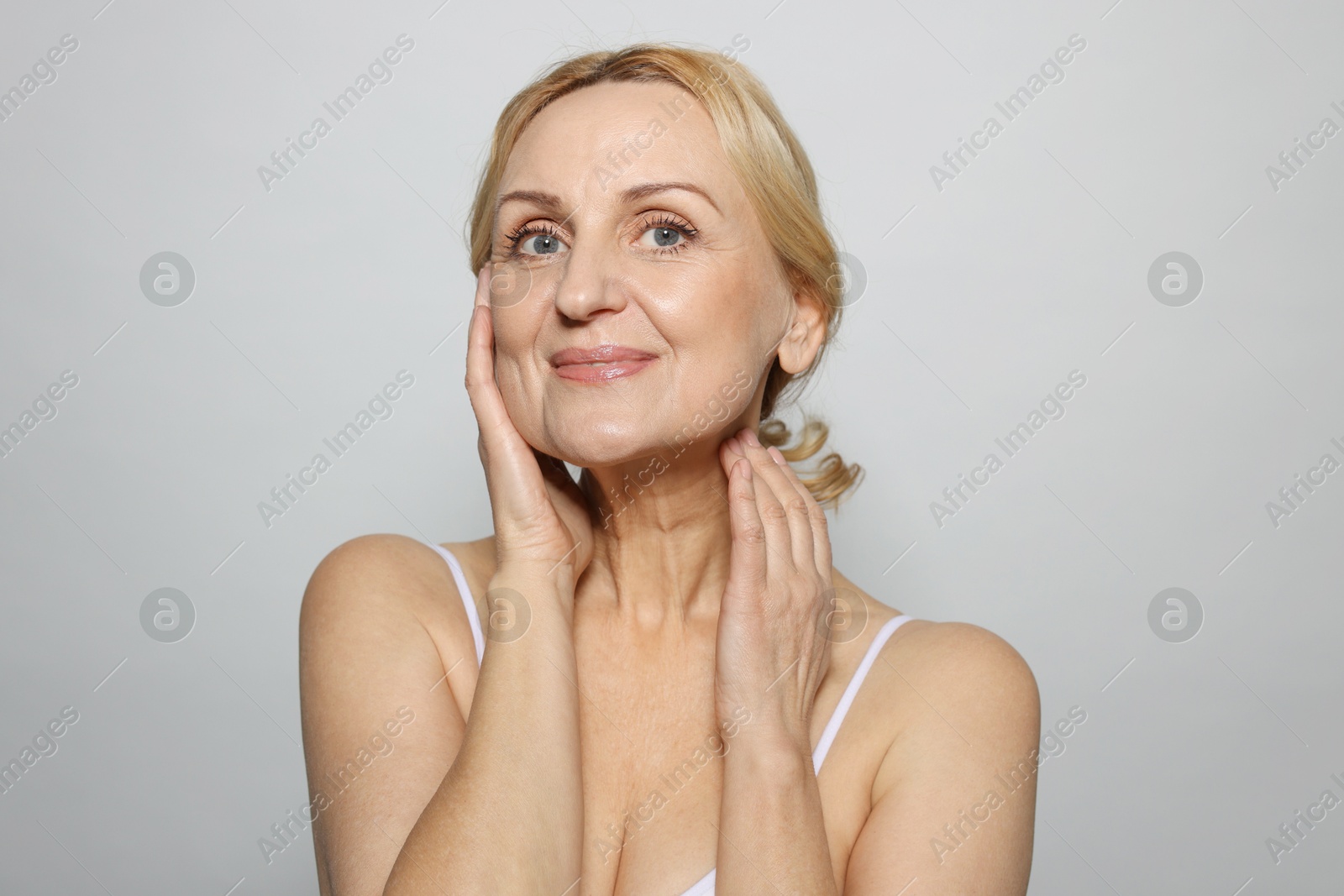 Photo of Portrait of beautiful middle aged woman on grey background