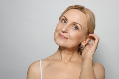 Photo of Portrait of beautiful middle aged woman on grey background