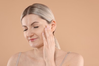 Portrait of beautiful woman on beige background. Space for text