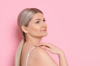 Portrait of beautiful woman on pink background. Space for text