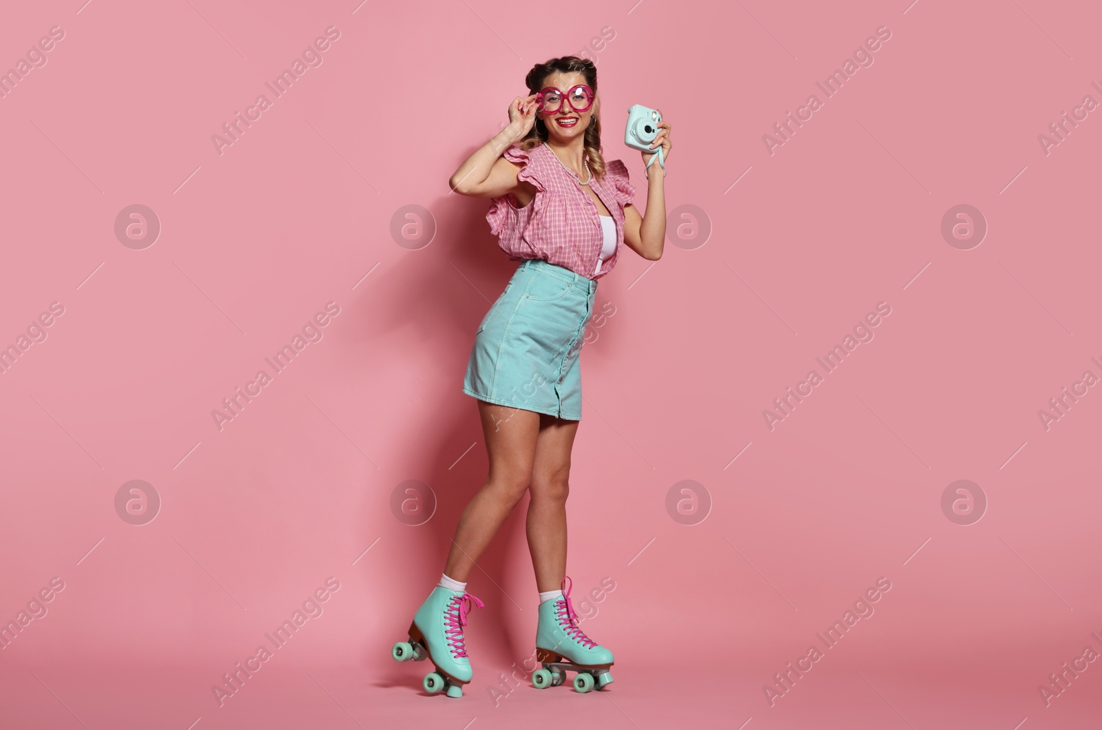 Photo of Happy pin-up woman with camera on pink background