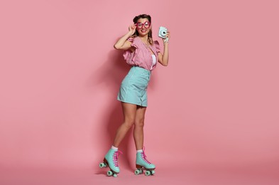 Photo of Happy pin-up woman with camera on pink background