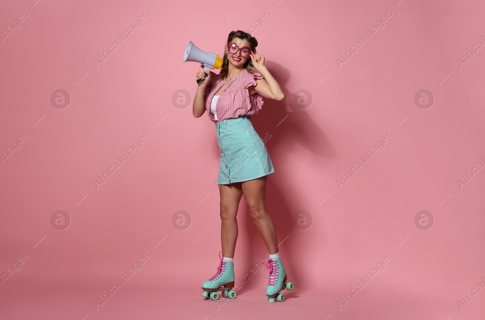 Photo of Happy pin-up woman with megaphone wearing roller skates on pink background