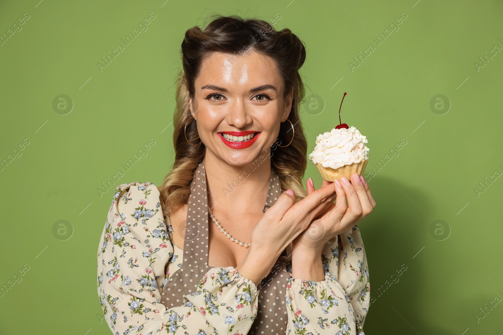 Photo of Happy woman with cupcake on green background. Pin-up vibe portrait