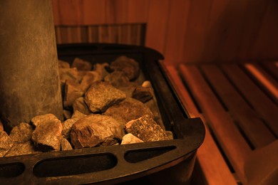 Stove with hot rocks in sauna, closeup. Space for text