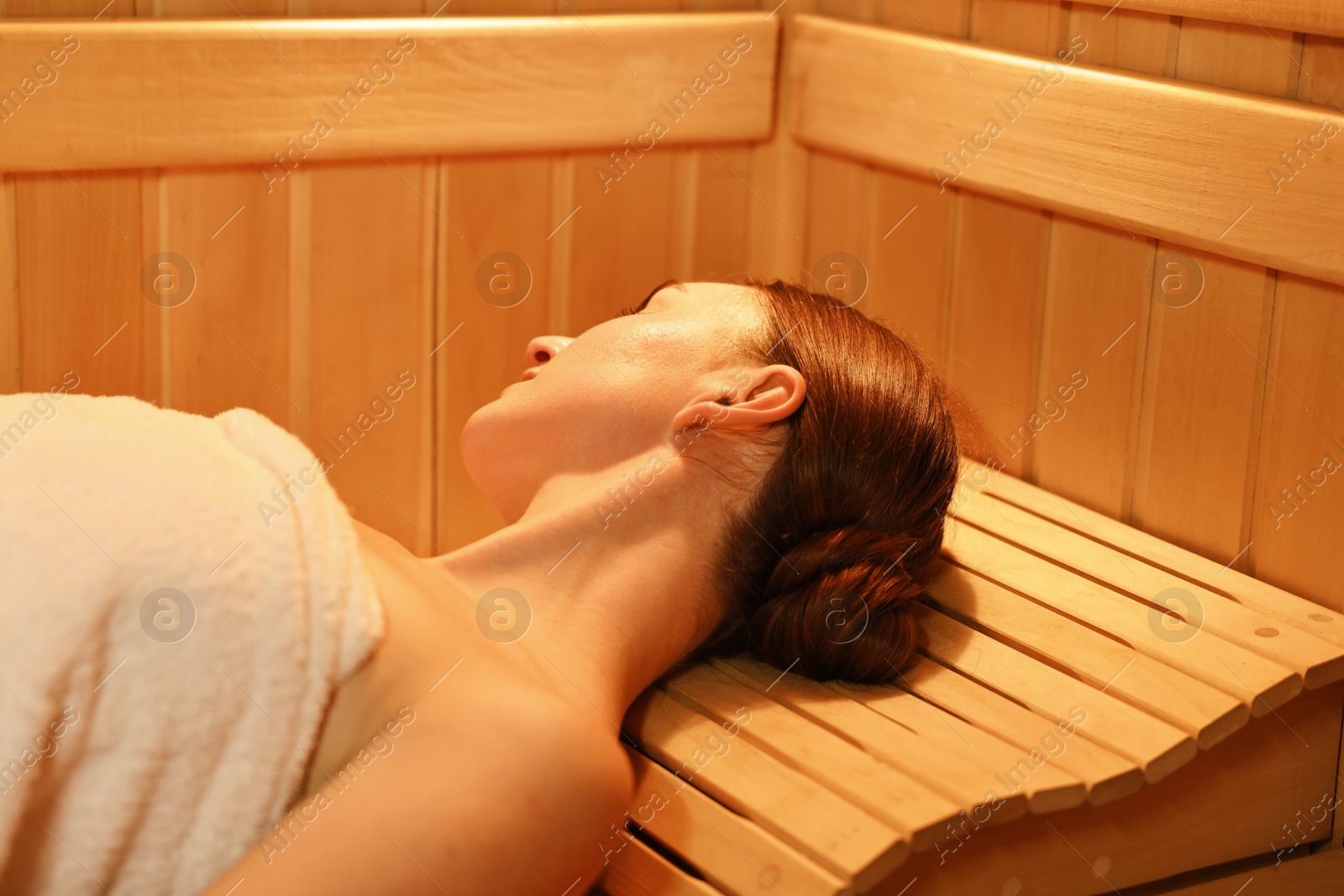 Photo of Beautiful woman relaxing on bench in sauna