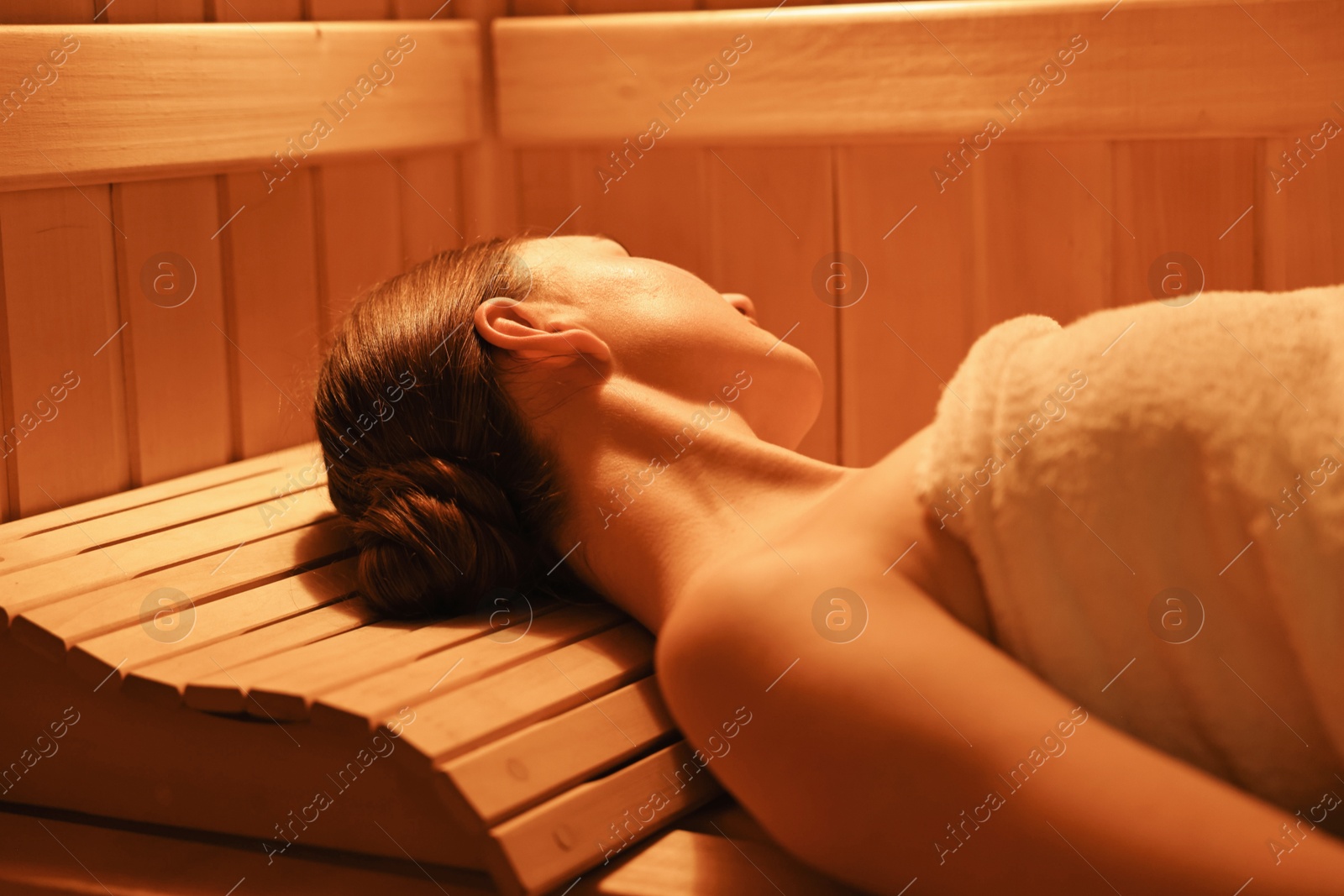 Photo of Beautiful woman relaxing on bench in sauna