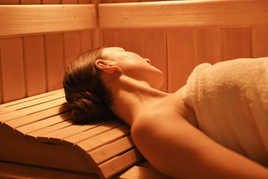 Photo of Beautiful woman relaxing on bench in sauna