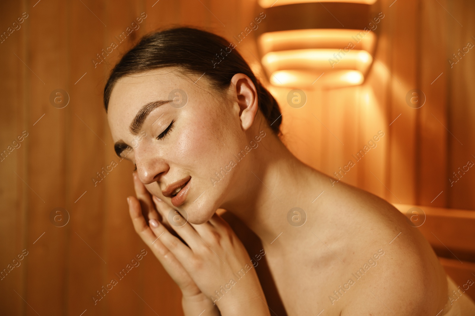 Photo of Beautiful young woman relaxing in hot sauna