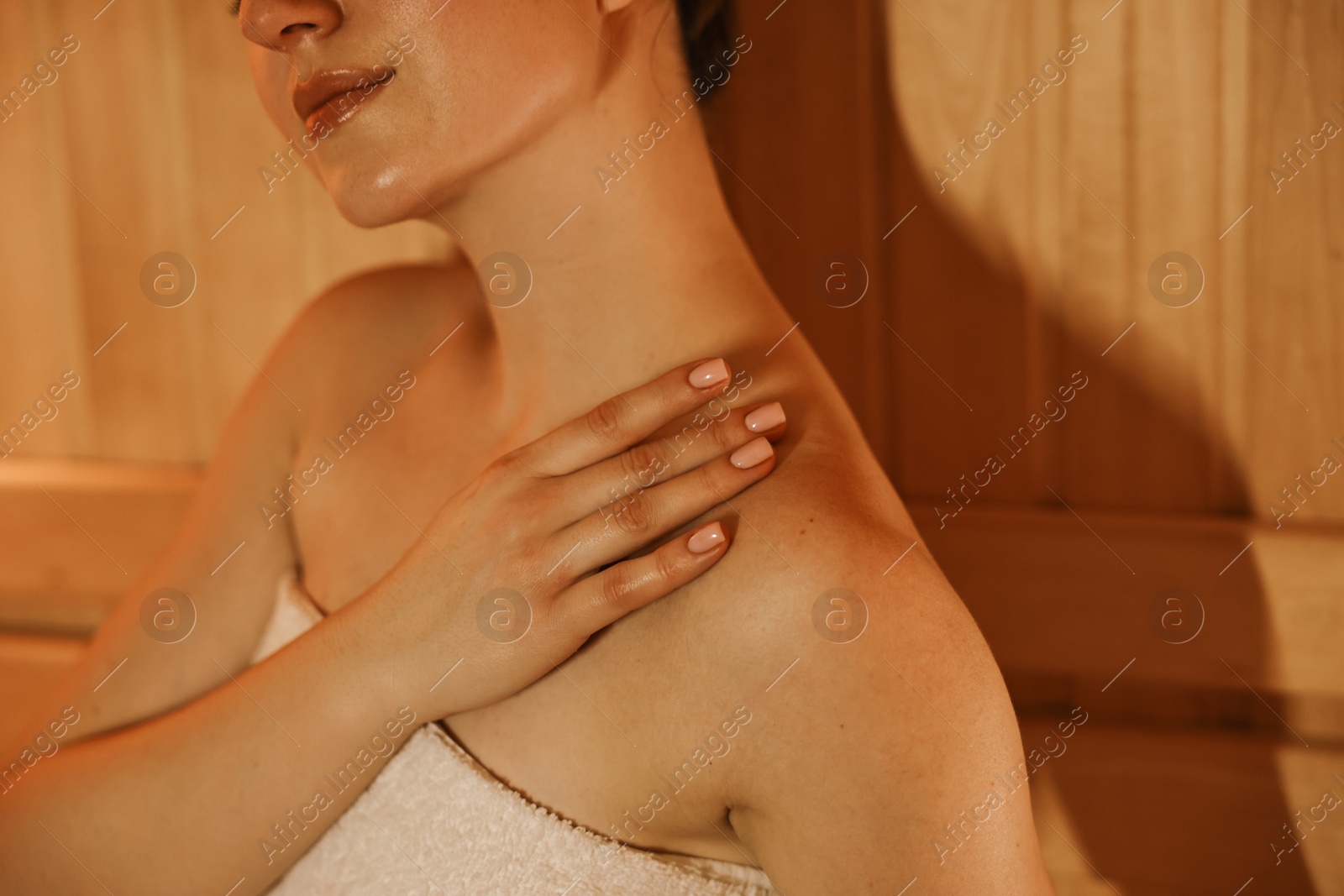 Photo of Young woman relaxing in hot sauna, closeup