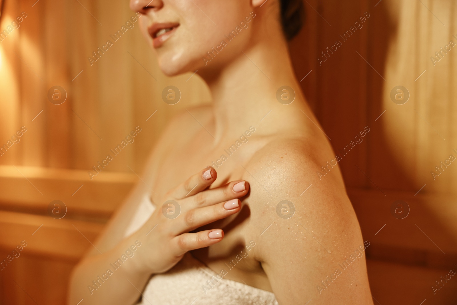 Photo of Young woman relaxing in hot sauna, closeup