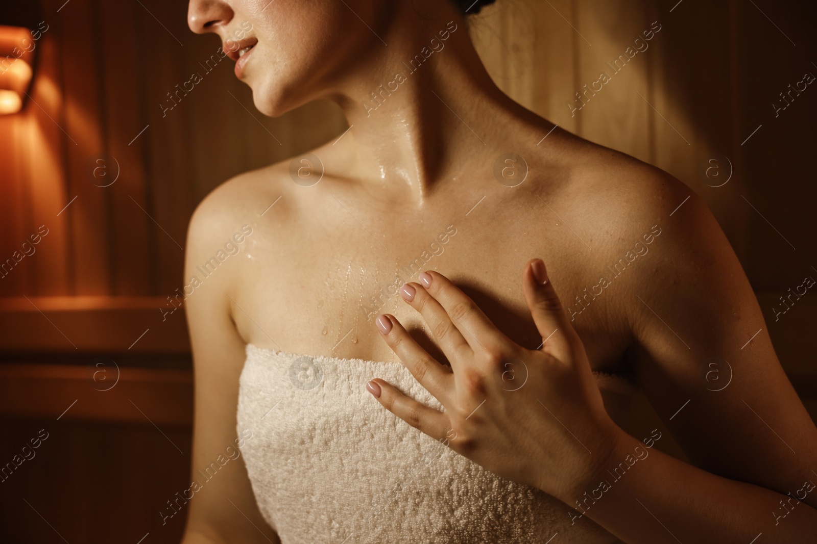 Photo of Young woman relaxing in hot sauna, closeup