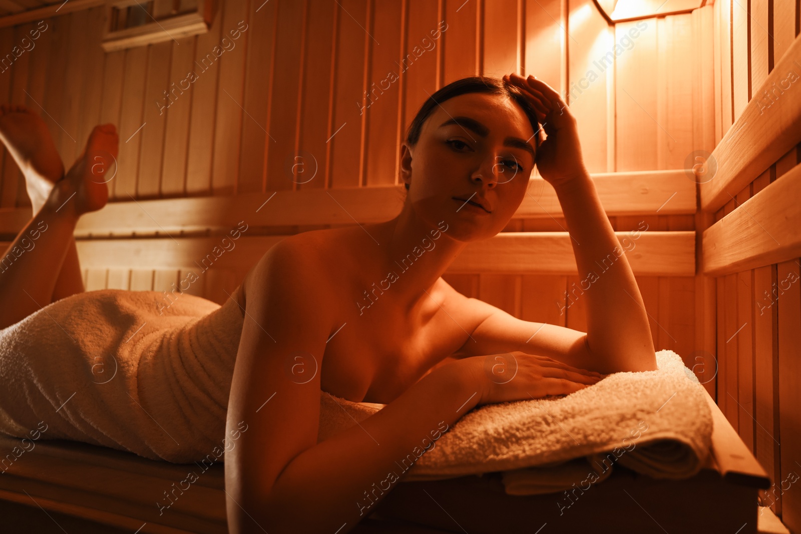 Photo of Beautiful woman lying on bench in sauna