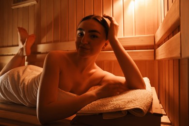 Photo of Beautiful woman lying on bench in sauna