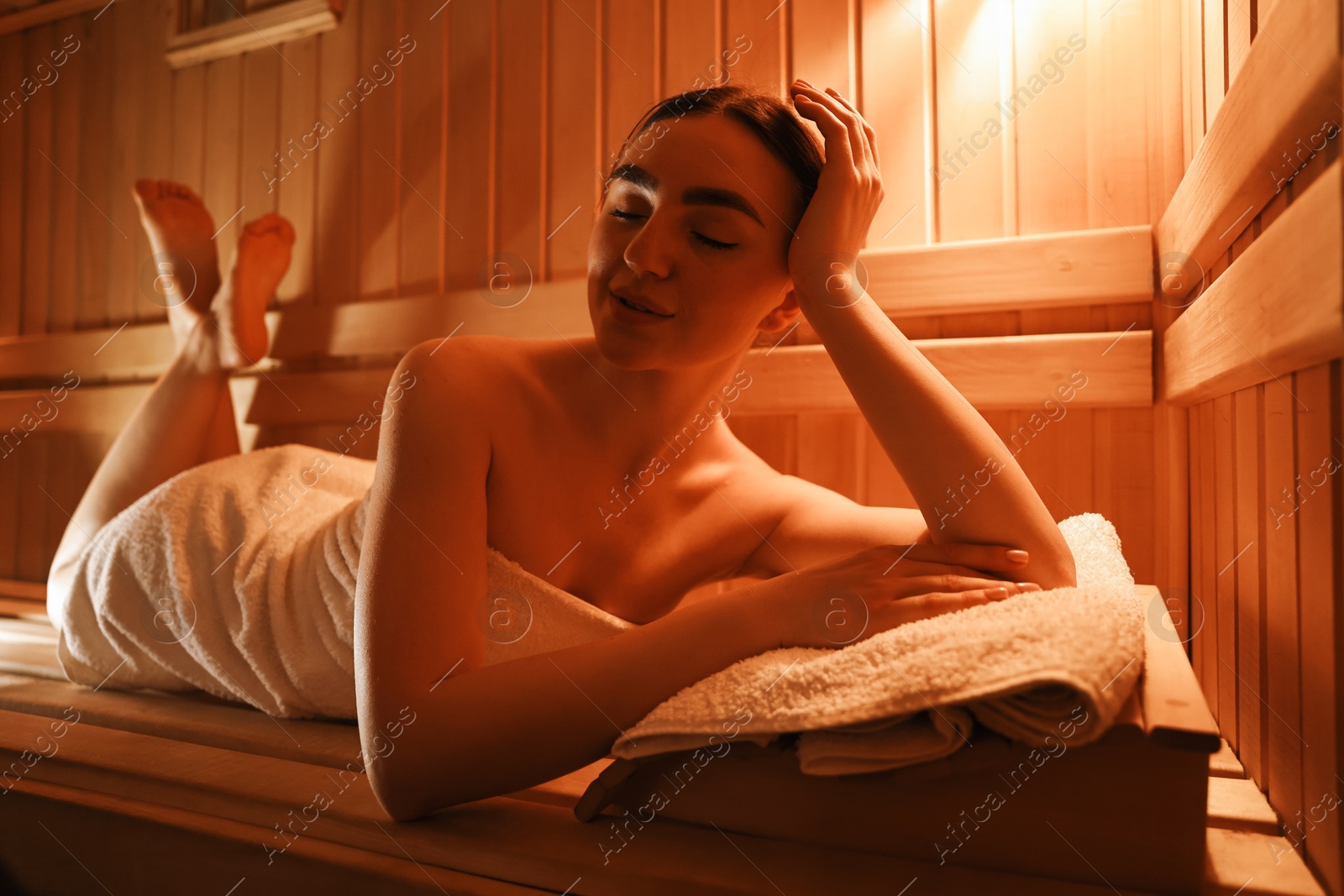 Photo of Beautiful woman lying on bench in sauna