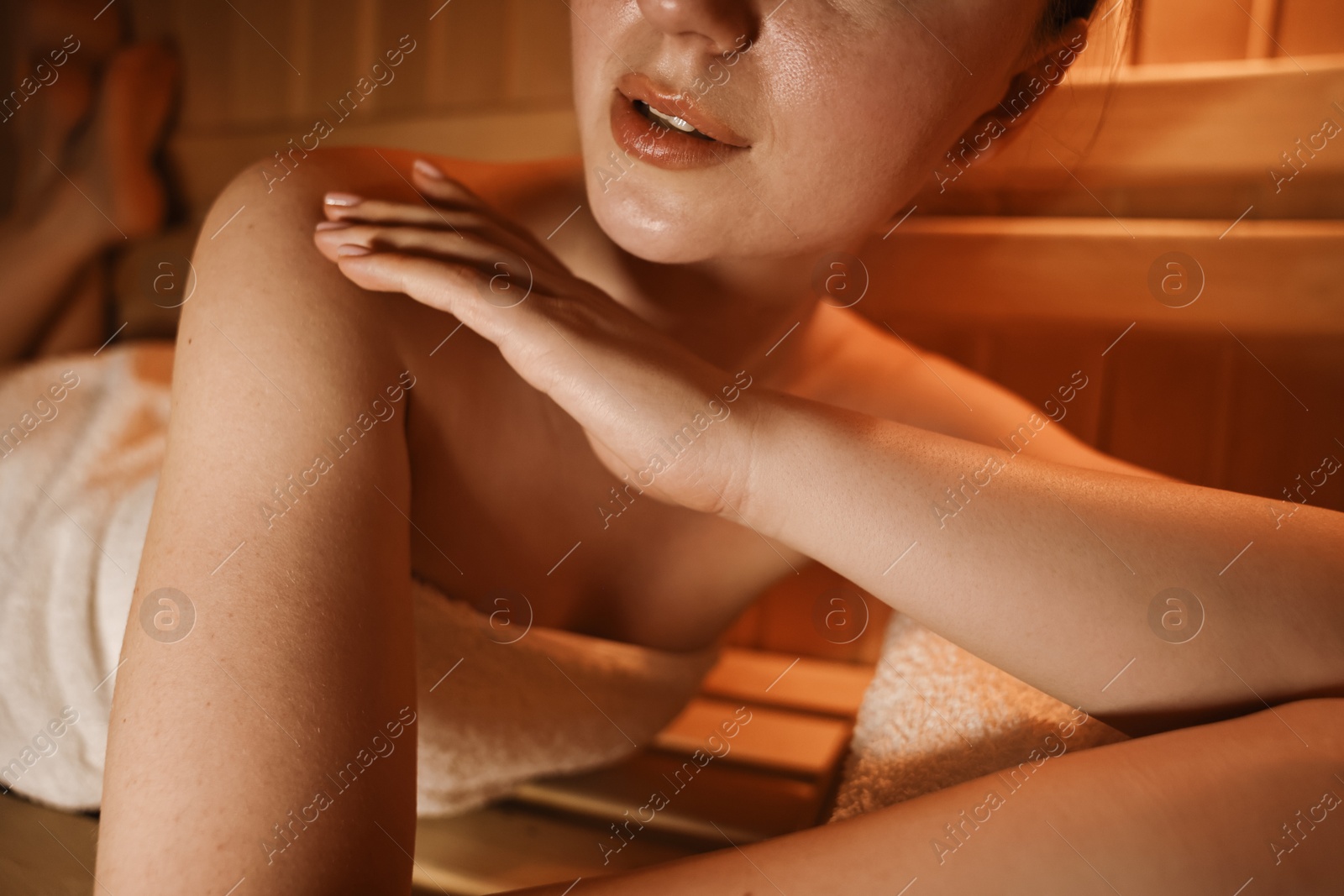 Photo of Woman lying on bench in sauna, closeup